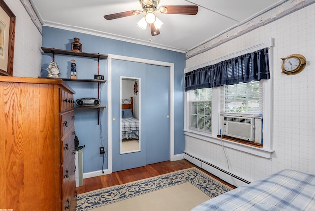 bedroom featuring a ceiling fan, wood finished floors, cooling unit, a baseboard heating unit, and a closet