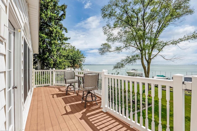 wooden deck featuring a lawn and a water view