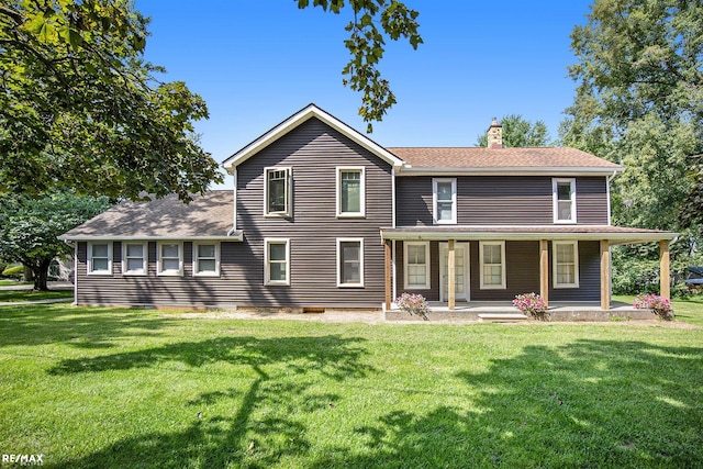 back of property featuring a porch and a yard