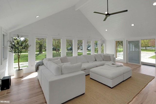 living room featuring a wealth of natural light, high vaulted ceiling, and light wood-type flooring