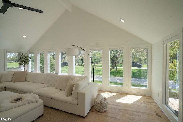 sunroom featuring lofted ceiling with beams, ceiling fan, and a healthy amount of sunlight