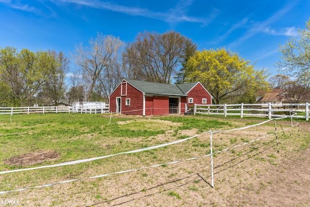 view of outbuilding with a rural view and a lawn