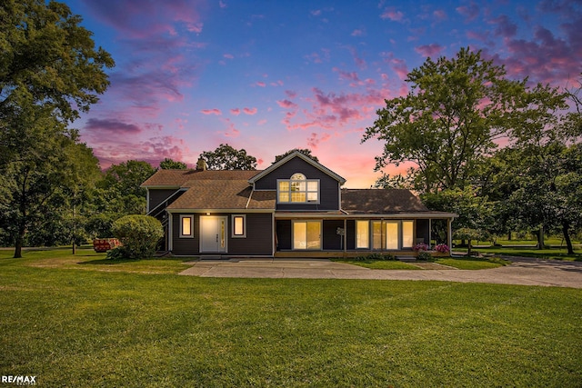 view of front of home featuring covered porch and a yard