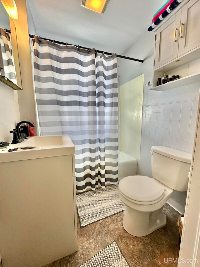 full bathroom with tile patterned flooring, toilet, vanity, and shower / bath combo with shower curtain