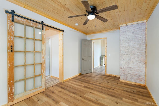 empty room with radiator, wood ceiling, a barn door, ceiling fan, and light wood-type flooring