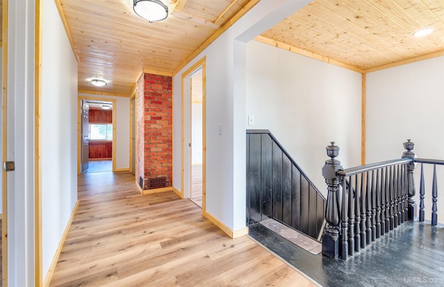 hallway with wood ceiling, brick wall, ornamental molding, and hardwood / wood-style flooring