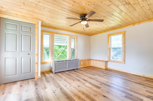 interior space featuring ceiling fan, radiator, light wood-type flooring, and wooden ceiling