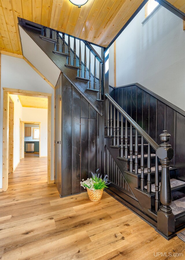 stairs with wooden ceiling and hardwood / wood-style flooring