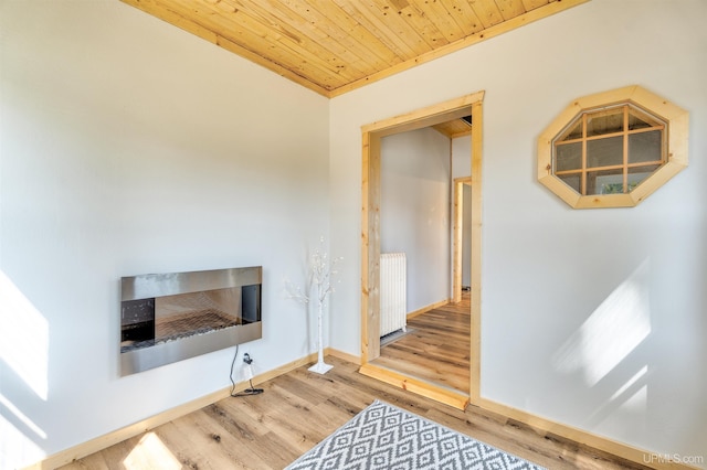 living room with radiator, light hardwood / wood-style flooring, and wood ceiling