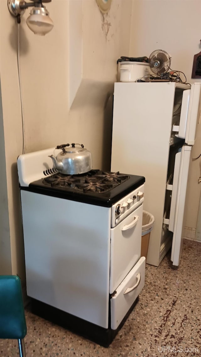 kitchen with white cabinetry and white gas stove