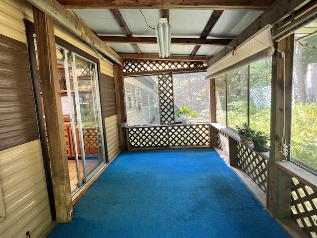 sunroom / solarium with a healthy amount of sunlight and beamed ceiling