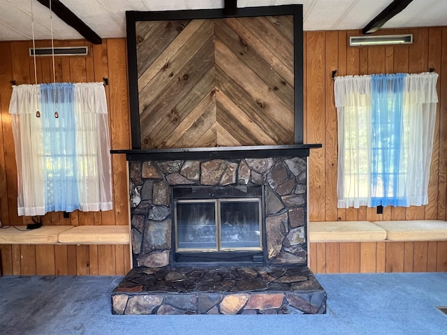 details featuring wooden walls, a fireplace, visible vents, beamed ceiling, and carpet