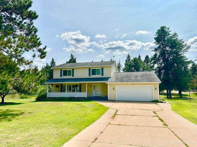 view of front of property featuring a front yard, a garage, and covered porch