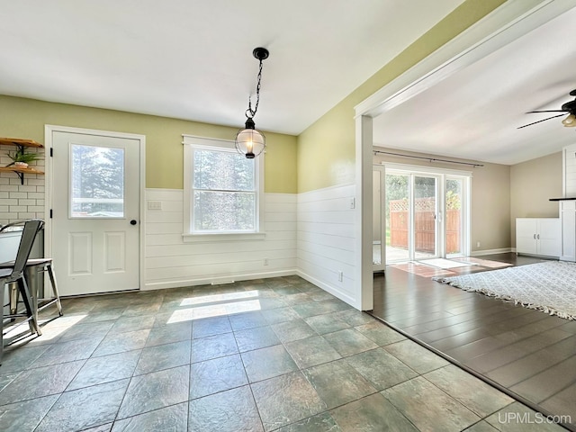 doorway with tile patterned flooring and ceiling fan