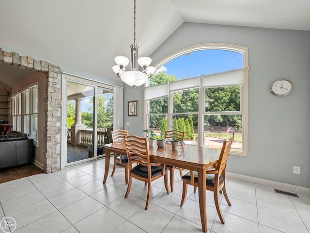 tiled dining area with an inviting chandelier, lofted ceiling, and a healthy amount of sunlight