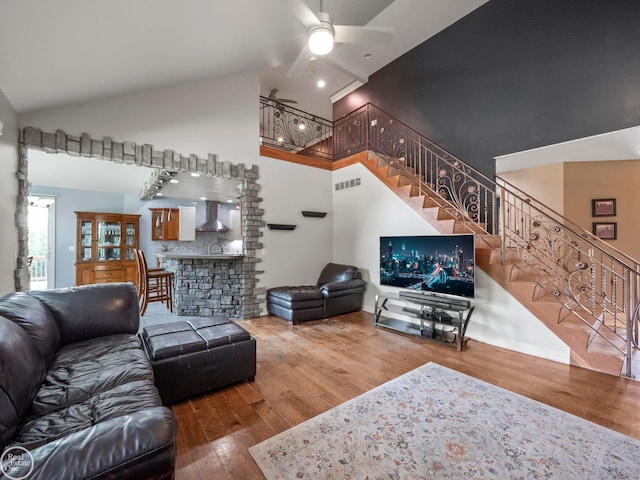 living room with ceiling fan, high vaulted ceiling, and wood-type flooring