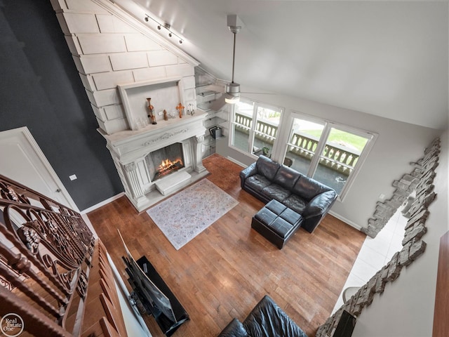 living room with ceiling fan, high vaulted ceiling, track lighting, and hardwood / wood-style floors