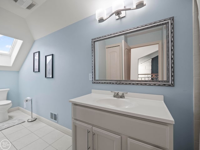 bathroom featuring tile patterned flooring, lofted ceiling with skylight, vanity, and toilet