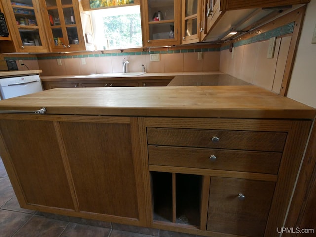 kitchen featuring sink, dark tile patterned floors, decorative backsplash, and white dishwasher