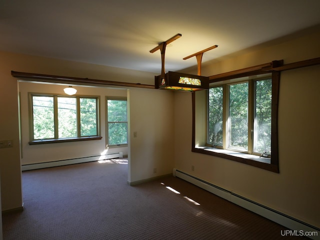 carpeted spare room with a baseboard radiator and a wealth of natural light