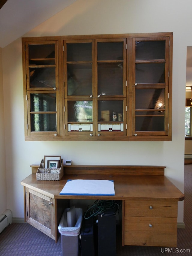 interior space featuring carpet floors, built in desk, and a baseboard heating unit