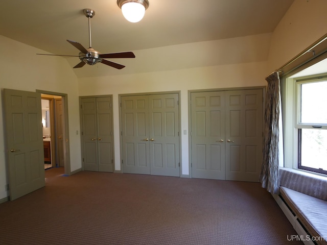 unfurnished bedroom with ceiling fan, multiple closets, vaulted ceiling, and carpet flooring