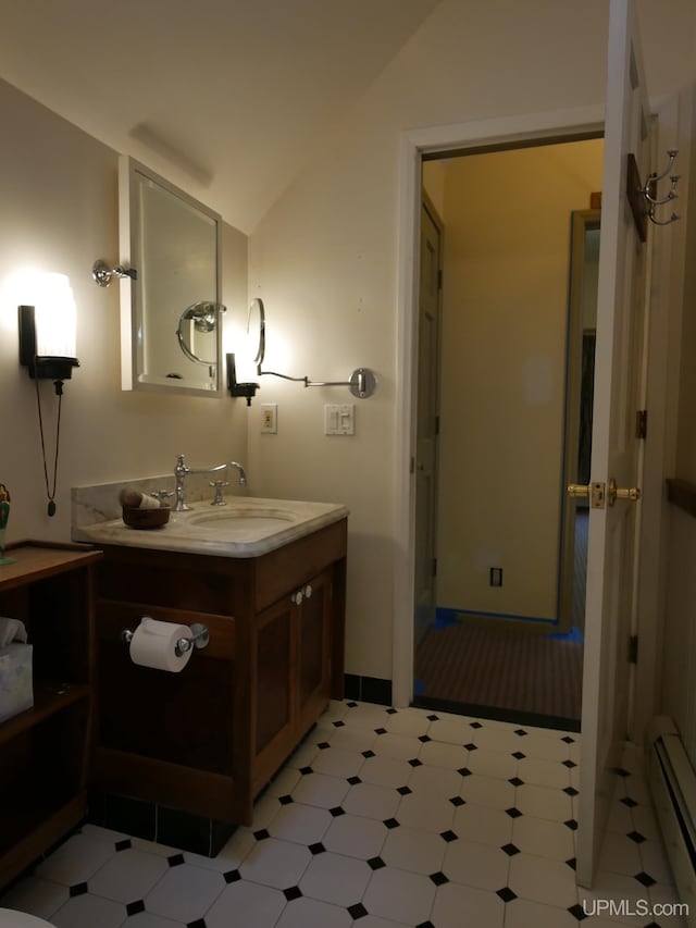 bathroom featuring tile patterned floors, lofted ceiling, vanity, and a baseboard radiator