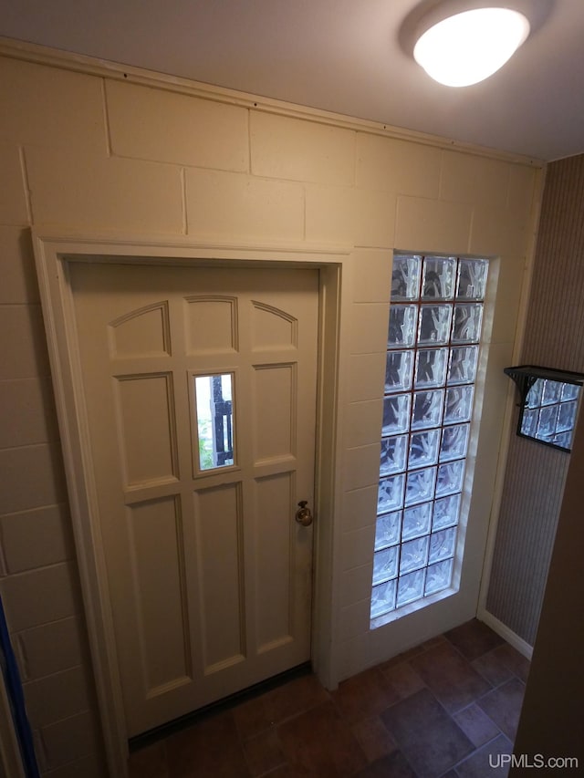 entryway with dark tile patterned floors