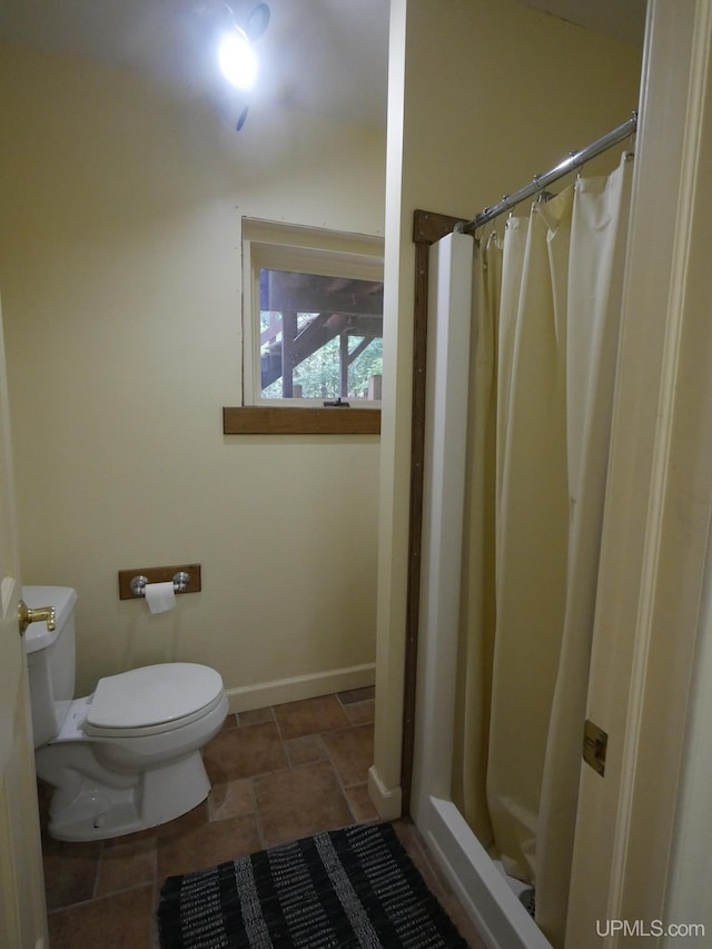 bathroom featuring toilet, tile patterned flooring, and curtained shower