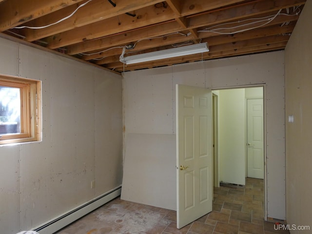 spare room featuring a baseboard heating unit and tile patterned floors