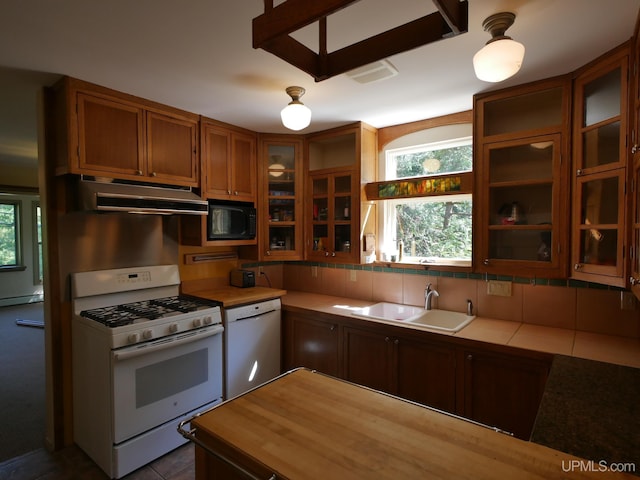 kitchen with baseboard heating, tasteful backsplash, tile patterned floors, sink, and white appliances