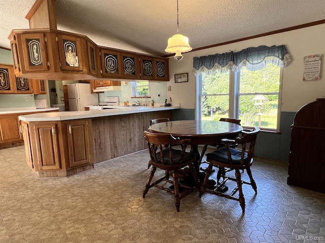dining room featuring wainscoting, crown molding, a textured ceiling, and tile patterned floors