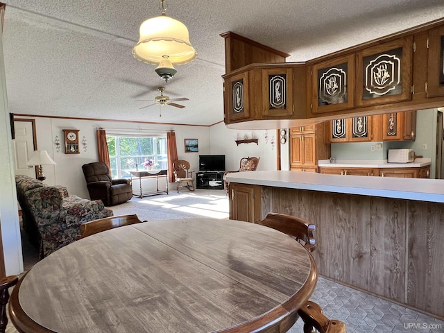 dining area featuring a textured ceiling, ornamental molding, and a ceiling fan
