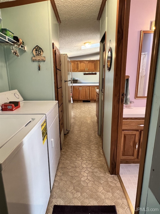 washroom featuring laundry area, a textured ceiling, and separate washer and dryer