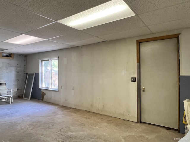 unfurnished room featuring concrete flooring and a drop ceiling