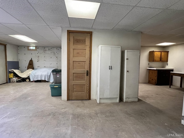 interior space with a paneled ceiling and concrete floors