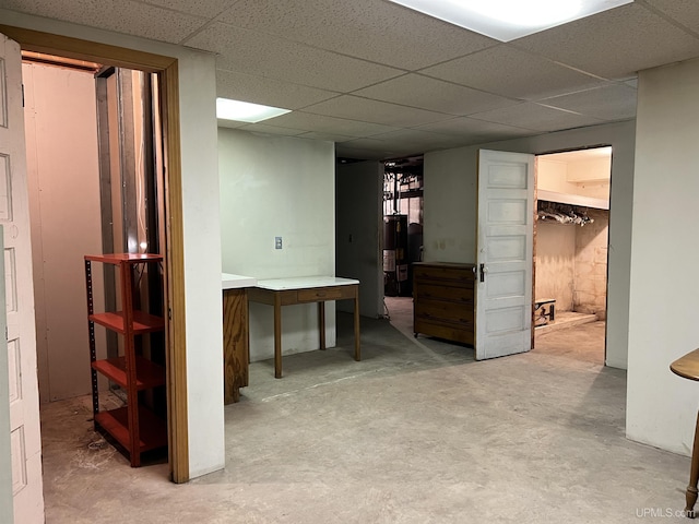 finished below grade area with water heater and a paneled ceiling