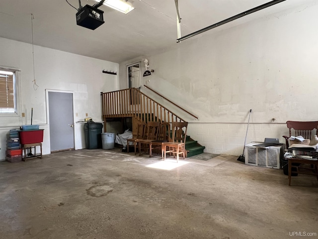garage with concrete block wall and a garage door opener