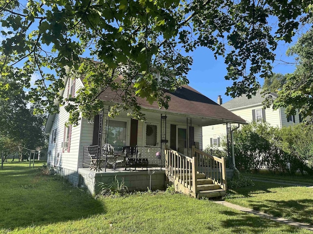 view of front of house with covered porch and a front lawn