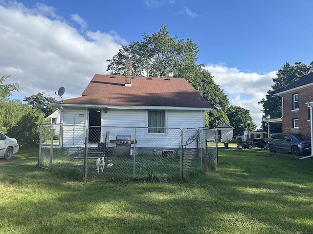 back of property featuring fence and a yard