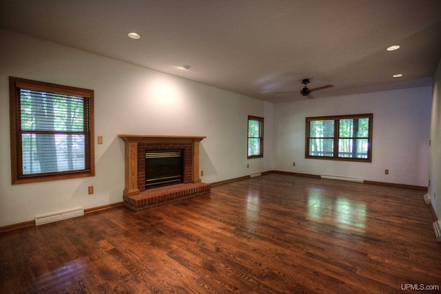 unfurnished living room featuring ceiling fan, a baseboard radiator, dark hardwood / wood-style flooring, and a fireplace