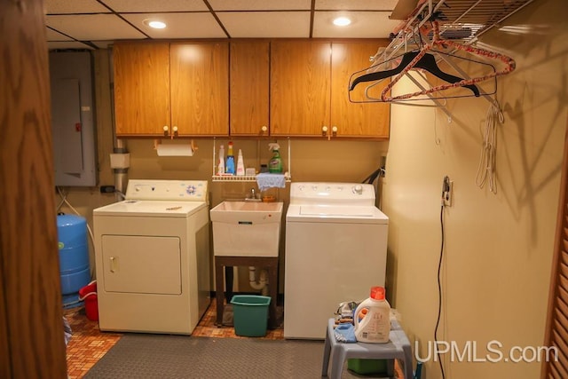 laundry area featuring washer and dryer, electric panel, and cabinets