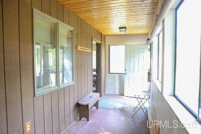 unfurnished sunroom featuring wood ceiling and a healthy amount of sunlight