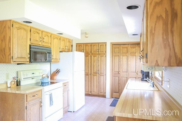 kitchen with sink, white appliances, and light tile patterned floors