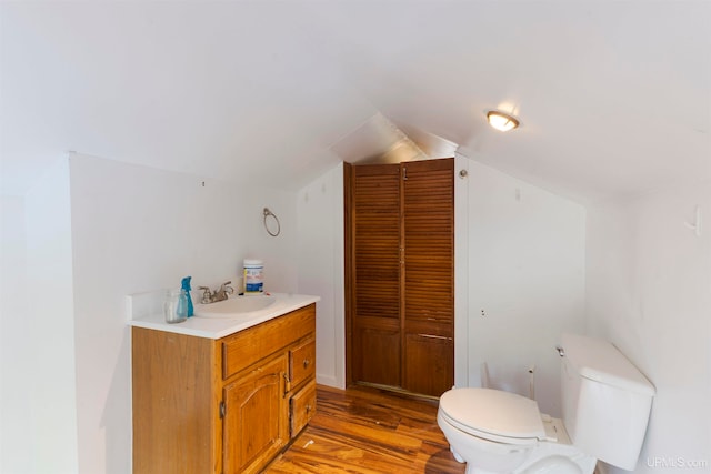 bathroom featuring lofted ceiling, vanity, toilet, and hardwood / wood-style flooring