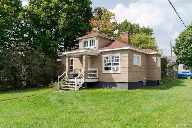 rear view of house featuring a lawn