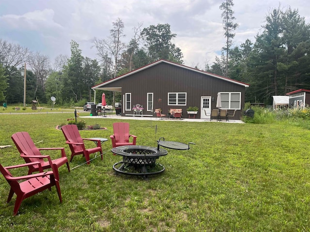 view of yard with an outdoor structure, a patio area, and a fire pit