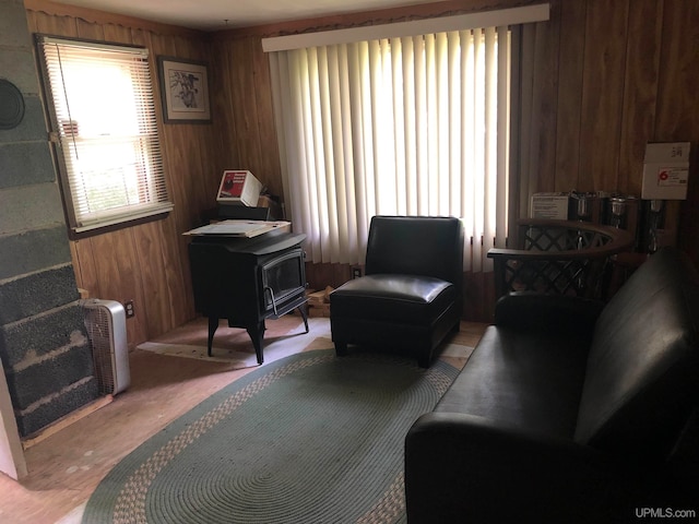 living room featuring wood walls and a wood stove