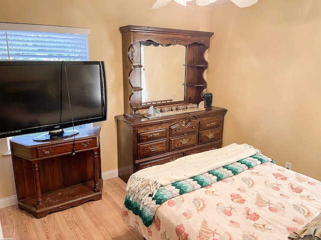 bedroom with ceiling fan, multiple windows, and light hardwood / wood-style floors