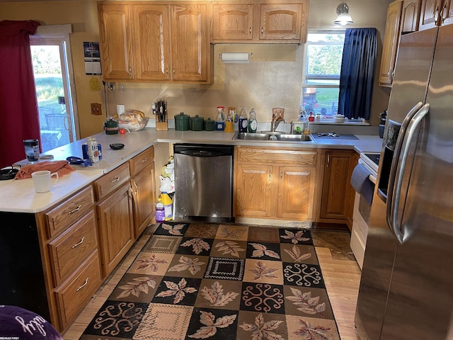 kitchen with a wealth of natural light, stainless steel appliances, sink, and light wood-type flooring